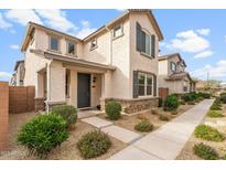 Charming two-story home features desert landscaping, gray shutters, and covered front porch at 25268 N 142Nd Dr, Surprise, AZ 85387