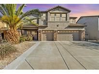 Two story stucco home with a three car garage, desert landscaping, and a large palm tree at 29740 W Fairmount Ave, Buckeye, AZ 85396