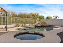 Pool and spa combo in backyard boasts a rock waterfall feature, creating a backyard paradise at 3746 E Vallejo Dr, Gilbert, AZ 85298