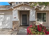 Close-up of home's entrance with stone accents on columns, bougainvillea and a well-manicured lawn at 3746 E Vallejo Dr, Gilbert, AZ 85298