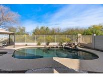 Sparkling pool and spa with decorative rock feature and privacy fence surrounded by lush landscaping at 3746 E Vallejo Dr, Gilbert, AZ 85298