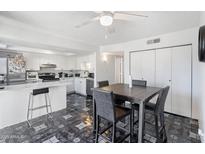 Bright kitchen area featuring white cabinetry, stainless steel appliances, and dining table with modern chairs at 6345 N 49Th Ave, Glendale, AZ 85301