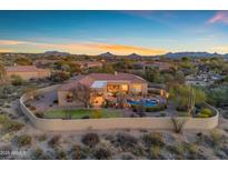Stunning backyard featuring a pool, spa, patio, and lush landscaping with beautiful desert views at 8320 E Arroyo Hondo Rd, Scottsdale, AZ 85266