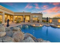 A backyard pool includes water features, spa, fire pit, and desert landscaping at 8320 E Arroyo Hondo Rd, Scottsdale, AZ 85266