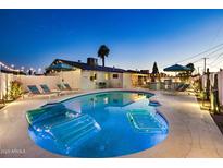 Inviting backyard pool area featuring an in-ground pool, lounge chairs, and manicured landscaping under a twilight sky at 8640 E Dianna Dr, Scottsdale, AZ 85257