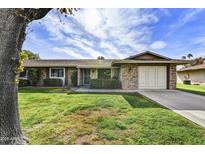 Charming brick home featuring a well-manicured lawn and mature shade tree at 9813 W Pleasant Valley Rd, Sun City, AZ 85351