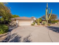 Charming home with a three car garage and a long driveway lined with desert landscaping at 18716 E White Wing Dr, Rio Verde, AZ 85263