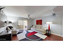 Bright living room featuring a sofa, patterned chair, and sliding glass door to the patio at 1880 E Morten Ave # 130, Phoenix, AZ 85020