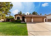 Charming single-story home with a well-manicured lawn and three-car garage at 265 E Liberty Ln, Gilbert, AZ 85296