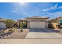 Tan home featuring a spacious driveway and desert landscaping at 41573 W Anne Ln, Maricopa, AZ 85138