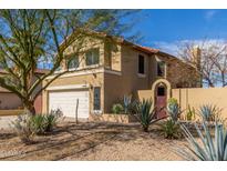 Inviting two-story home with desert landscaping, charming gate, and attached two-car garage at 4946 W Evans Dr, Glendale, AZ 85306