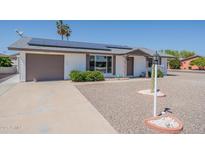 Charming single-story home with desert landscaping and solar panels on the roof at 11214 N 105Th Ave, Sun City, AZ 85351