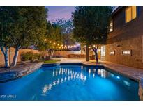 Backyard oasis featuring a sparkling pool, bar, and patio area, perfect for outdoor entertaining at 122 W Raven Dr, Chandler, AZ 85286