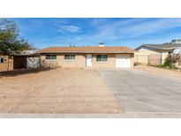 Single-story home features a spacious front yard with a long driveway and an attached single car garage at 12608 W Lower Buckeye Rd, Avondale, AZ 85323