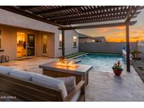 Inviting backyard features a cozy fire pit, comfortable seating, and a sparkling pool, perfect for outdoor entertaining at 17496 W Summit Dr, Goodyear, AZ 85338