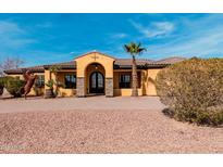 Inviting Mediterranean home boasts a barrel tile roof, stone accents, double door entry, and a manicured yard at 18332 W Latham St, Goodyear, AZ 85338