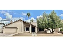 Charming single-story home with neutral stucco, a well-manicured lawn, and mature trees at 1938 E Myrna Ln, Tempe, AZ 85284