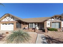 Charming single-story brick home featuring a well-manicured yard and inviting front porch at 2558 E Inglewood St, Mesa, AZ 85213