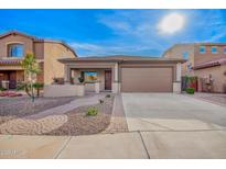 Charming single Gathering home with a well-manicured front yard and a two-car garage at 379 W Dragon Tree Ave, Queen Creek, AZ 85140