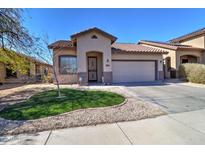 Charming single-story home featuring a well-manicured lawn and a two-car garage on a sunny day at 40716 N Hudson Trl, Anthem, AZ 85086