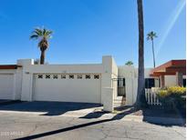 Charming single-story home features a two-car garage, courtyard entrance, and mature palm trees at 4765 W Mediterranean Dr, Glendale, AZ 85301