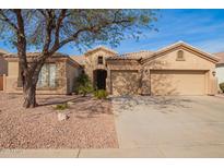 Charming home featuring a tile roof, three-car garage, and low-maintenance desert landscaping at 662 W Raven Dr, Chandler, AZ 85286