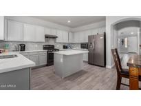 Modern kitchen features gray cabinets, stainless steel appliances, and a center island at 11851 W Alvarado Rd, Avondale, AZ 85392