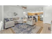 Comfortable living room featuring a sectional sofa, accent chair, and blue patterned rug open to the kitchen at 12050 N Panorama Dr # 107, Fountain Hills, AZ 85268