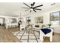 Open-concept living room featuring a large ceiling fan and plenty of natural light at 1236 E Nightingale Ln, Gilbert, AZ 85298