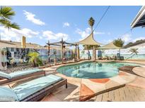 Outdoor oasis with a freeform pool, lush landscaping, and lounge chairs at 2505 E Hampton Ave, Mesa, AZ 85204