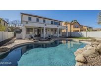 Enjoy this backyard pool with stone accents, lounge chairs and a covered patio, great for entertaining at 2506 E Bridgeport Pkwy, Gilbert, AZ 85295