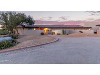 Warm desert home featuring desert landscaping, private courtyard, and red tiled roof at dusk at 36801 N Long Rifle Rd, Carefree, AZ 85377