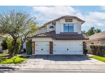 Charming two-story home with a well-manicured lawn and a spacious three-car garage at 3825 E Irwin Ave, Mesa, AZ 85206