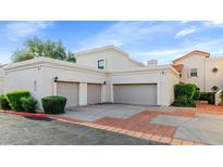 Beige stucco house with three-car garage and brick-lined driveway for a beautiful curb appeal at 7800 E Lincoln Dr # 1104, Scottsdale, AZ 85250