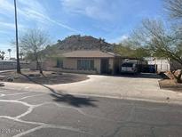 Single story home with a large front yard and driveway in front of a beautiful mountain view at 9804 N 5Th Ave, Phoenix, AZ 85021