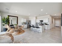 Bright, open kitchen with white cabinets, stainless steel appliances, and a cozy dining area at 1404 W Kennedy Ave, Coolidge, AZ 85128