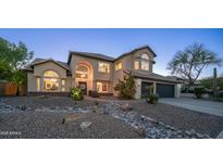 Stunning two-story home featuring a grand entrance, lush landscaping, and a charming rock river feature at 14052 S 24Th Way, Phoenix, AZ 85048