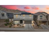 Charming two-story home featuring solar panels and a meticulously landscaped front yard against a mountain backdrop at 21186 W Hillcrest Blvd, Buckeye, AZ 85396