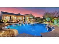 Beautiful backyard pool with a fire pit, outdoor kitchen, and lounge area at dusk at 31709 N 16Th Ave, Phoenix, AZ 85085