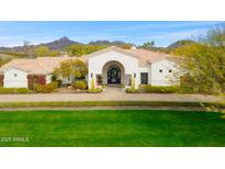 Stunning single-story home with a beautiful arched entryway, lush landscaping, and mountain views at 3246 E San Miguel Pl, Paradise Valley, AZ 85253