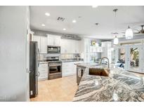 Bright kitchen featuring granite countertops, stainless steel appliances, and white cabinetry at 41921 N Crooked Stick Rd, Anthem, AZ 85086