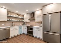 Updated kitchen features custom cabinets, stainless appliances, and stylish backsplash, perfect for modern living at 4201 E Camelback Rd # 34, Phoenix, AZ 85018