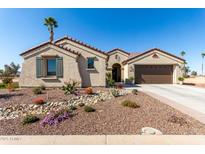 Charming home boasts a desert landscaped front yard, complete with vibrant flowers and a two-car garage at 5550 N Luna Dr, Eloy, AZ 85131