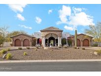 Beautiful home exterior with arched entryway, stone accents, fountain, and well-manicured desert landscaping at 8214 E Kael St, Mesa, AZ 85207