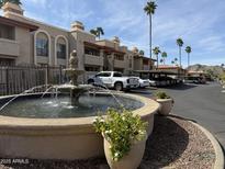 Exterior shot showcases lush landscaping, a water fountain, and ample parking in a well-maintained community at 10410 N Cave Creek Rd # 1103, Phoenix, AZ 85020