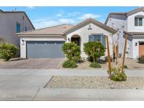 Charming single-story home with a two-car garage, desert landscaping, and neutral tones at 14254 W Cottontail Ln, Surprise, AZ 85387