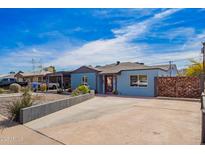 Charming blue home featuring a red front door and low maintenance desert landscaping at 217 W Montecito Ave, Phoenix, AZ 85013