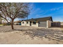 Charming home featuring a gravel front yard, a dark gray garage door, and beautiful curb appeal at 3034 W San Miguel Ave, Phoenix, AZ 85017