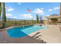 Refreshing pool with a tanning ledge, desert landscaping, and a pergola in a private backyard at 40504 N Territory Trl, Anthem, AZ 85086