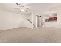 Spacious living room with neutral carpet, ceiling fans and staircase access to upper level at 5808 E Brown Rd # 110, Mesa, AZ 85205